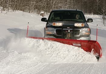 Pickup truck plowing a snow-covered road