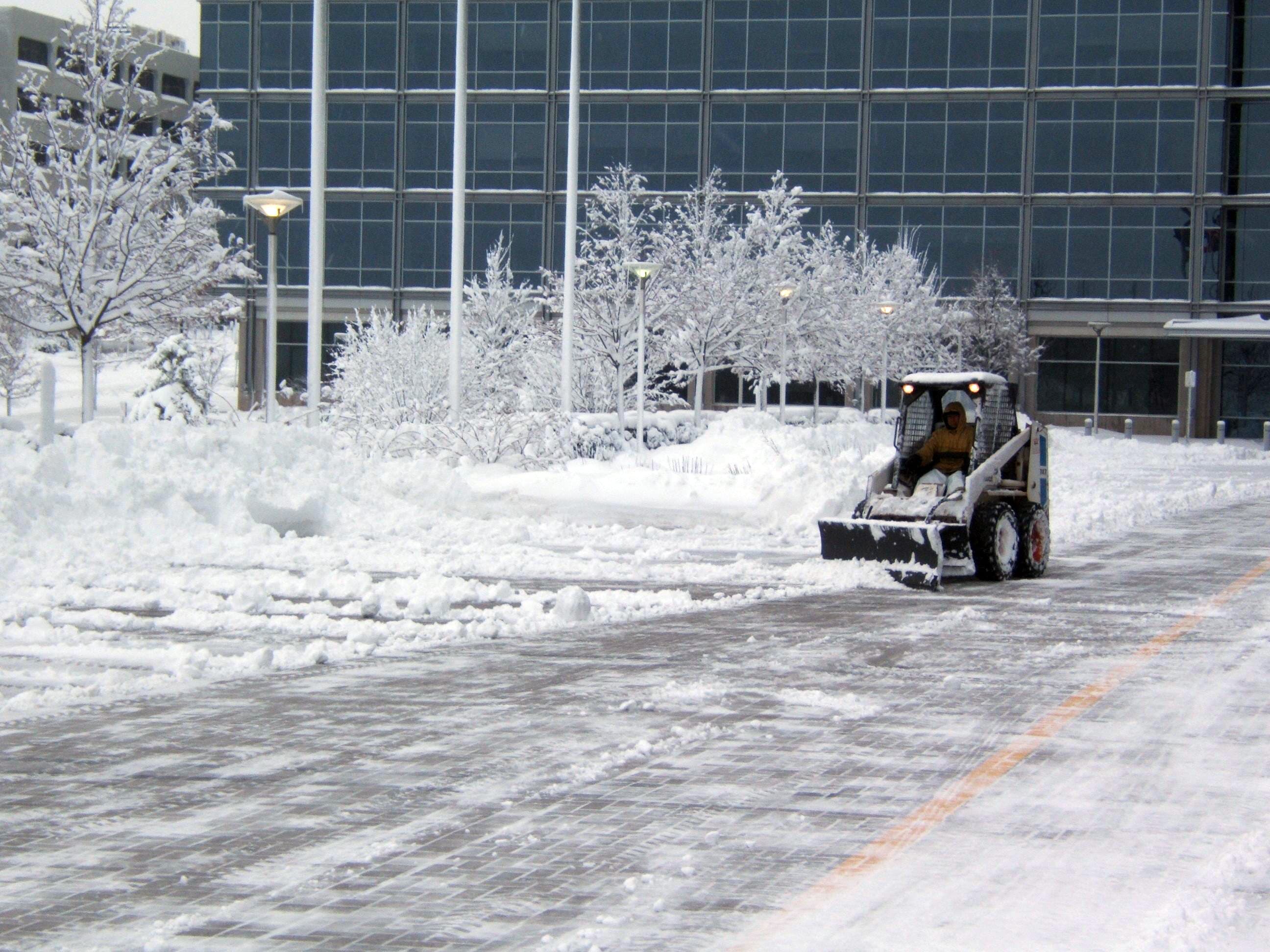 CPM crew clearing a commercial parking lot with a skid steer — snow plowing in Macedon, NY