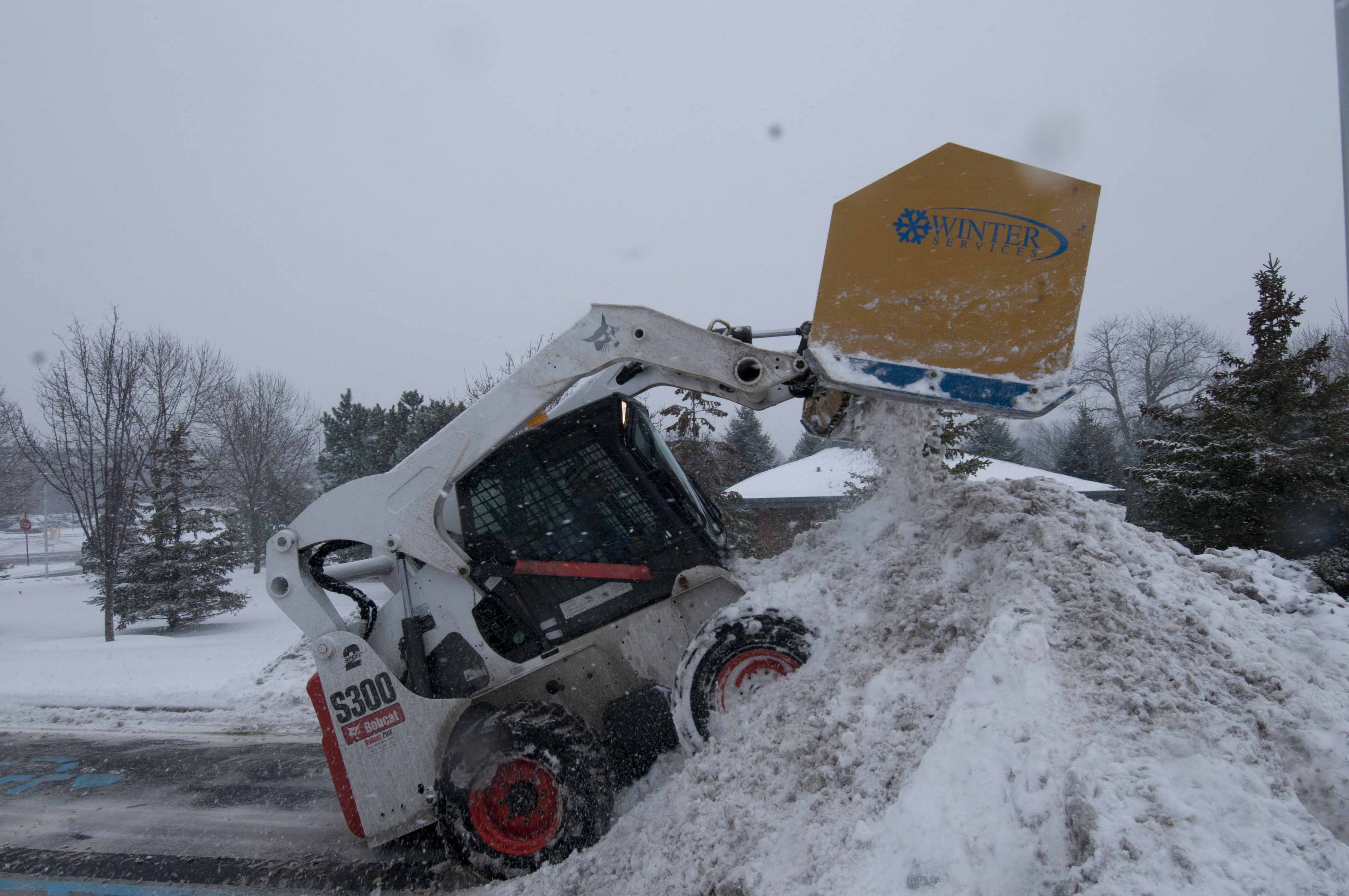 Skid steer hauling snow