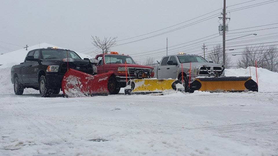 Three snow removal vehicles plowing streets
